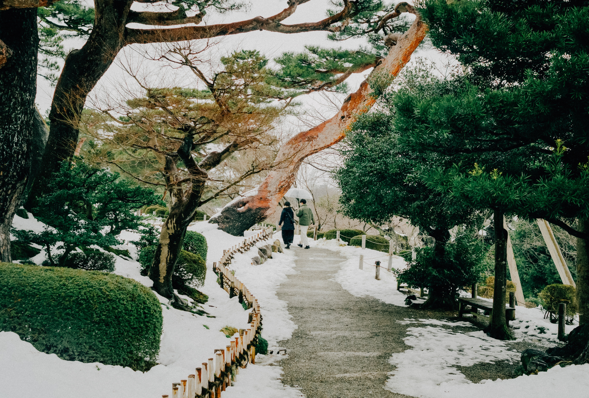 Dos personas pasean por un parque nevado en Kanazawa