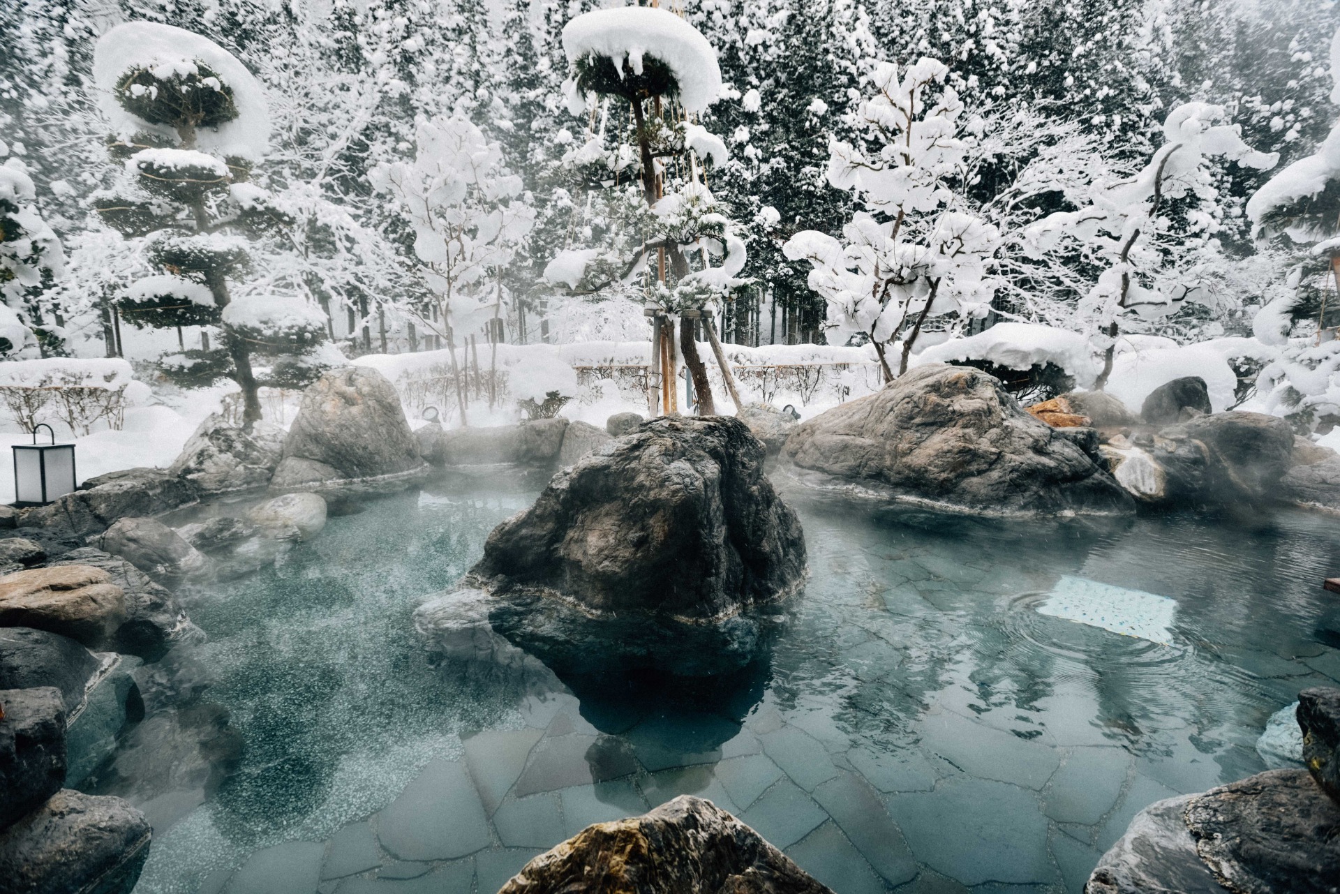 Un onsen al aire libre rodeado de nieve