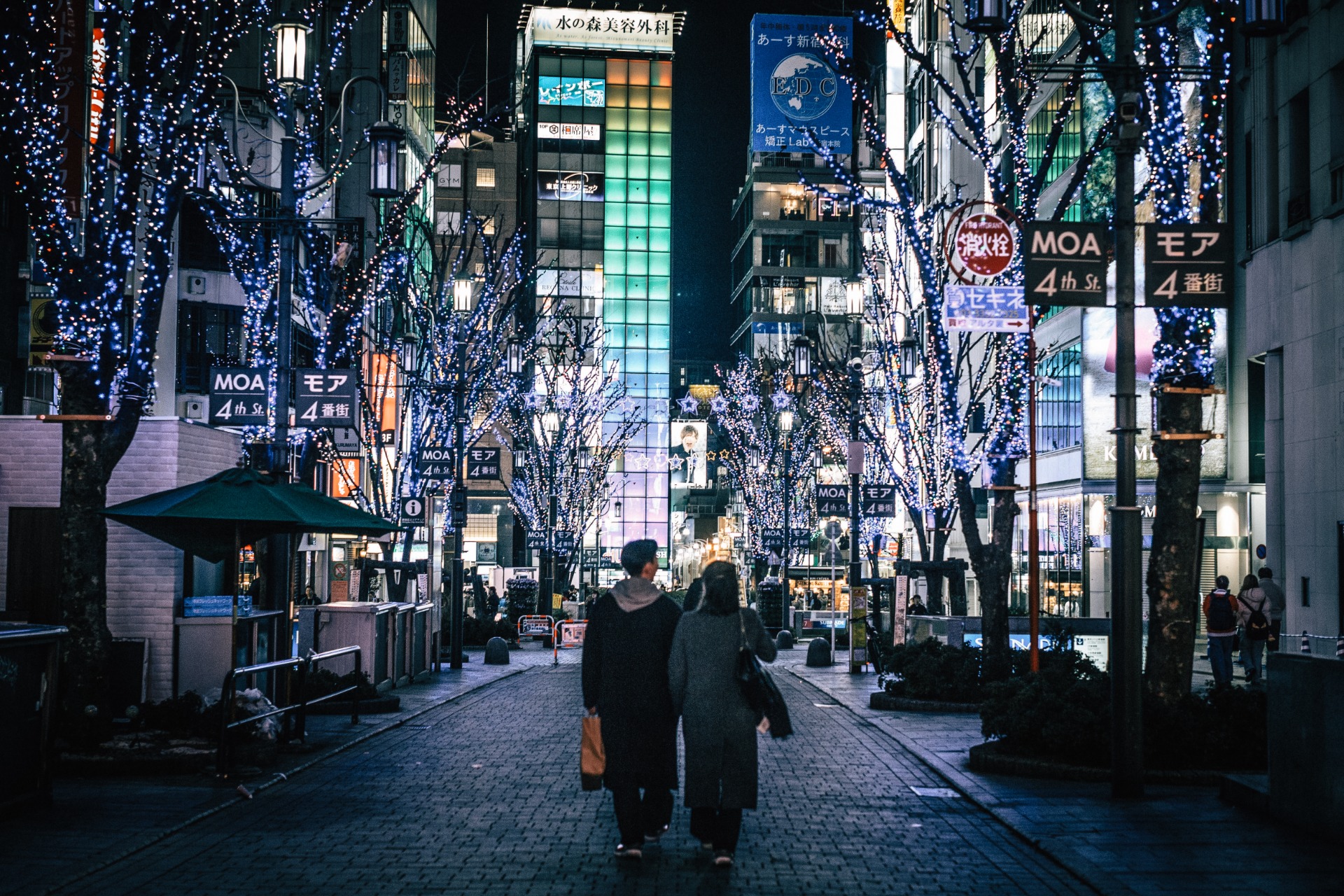 Pareja paseando de noche por una calle iluminada de Osaka
