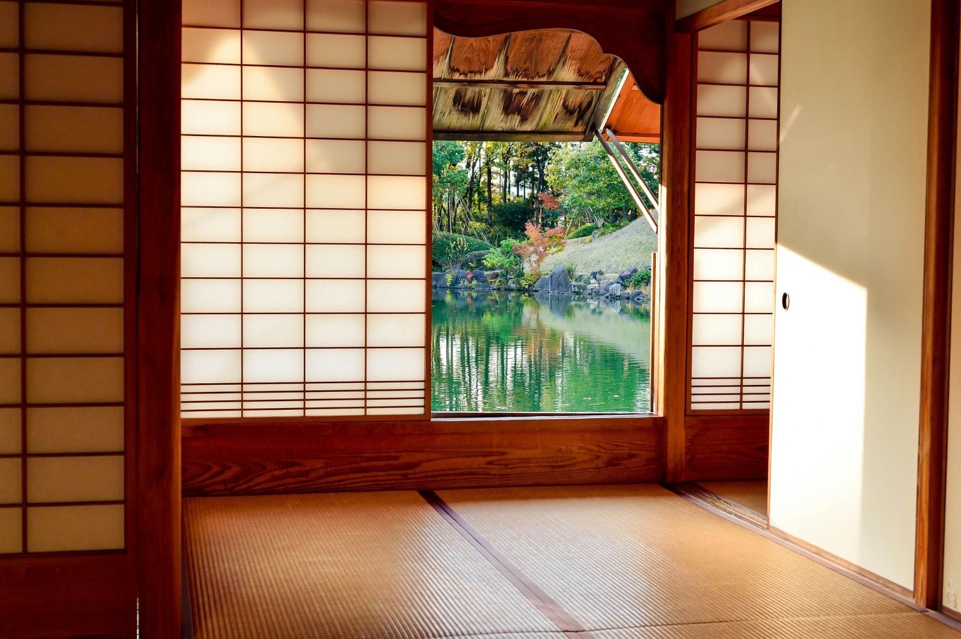 Vista desde una sala de tatami hacia un jardín japonés con estanque