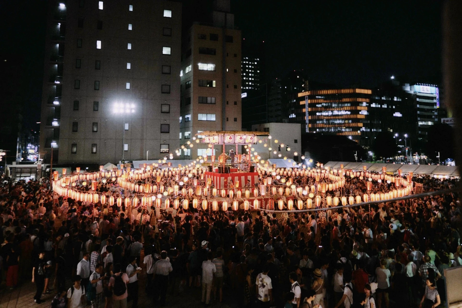 Escenario iluminado con farolillos durante un Bon Odori
