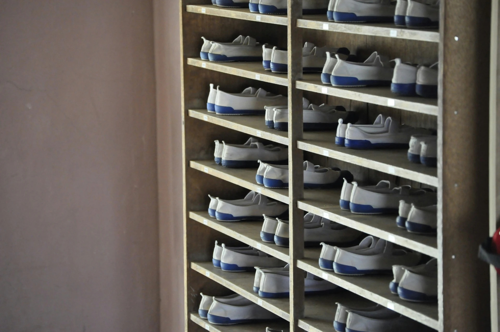 Una estantería con zapatillas uwabaki en un colegio
