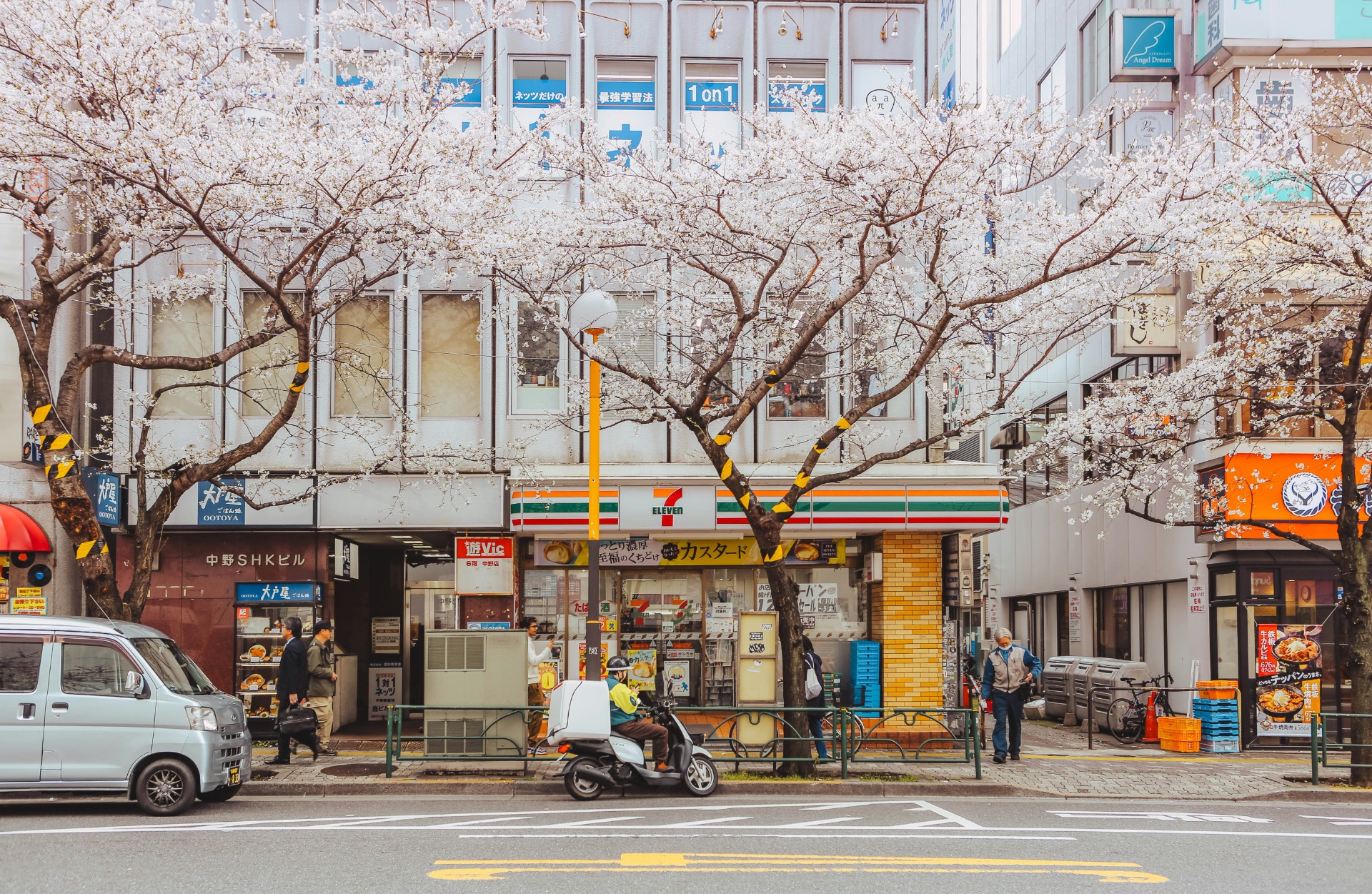 Tienda 7-Eleven en la ciudad con árboles en flor