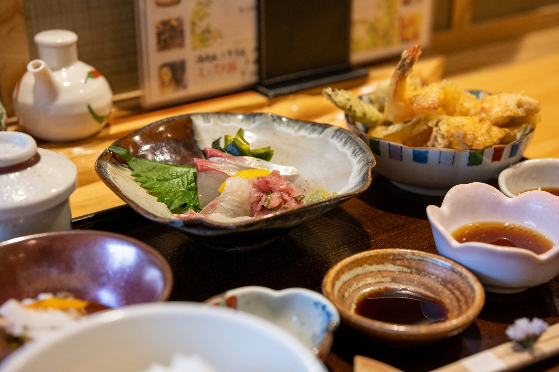 Teishoku japonés con sashimi variado, tempura y sake