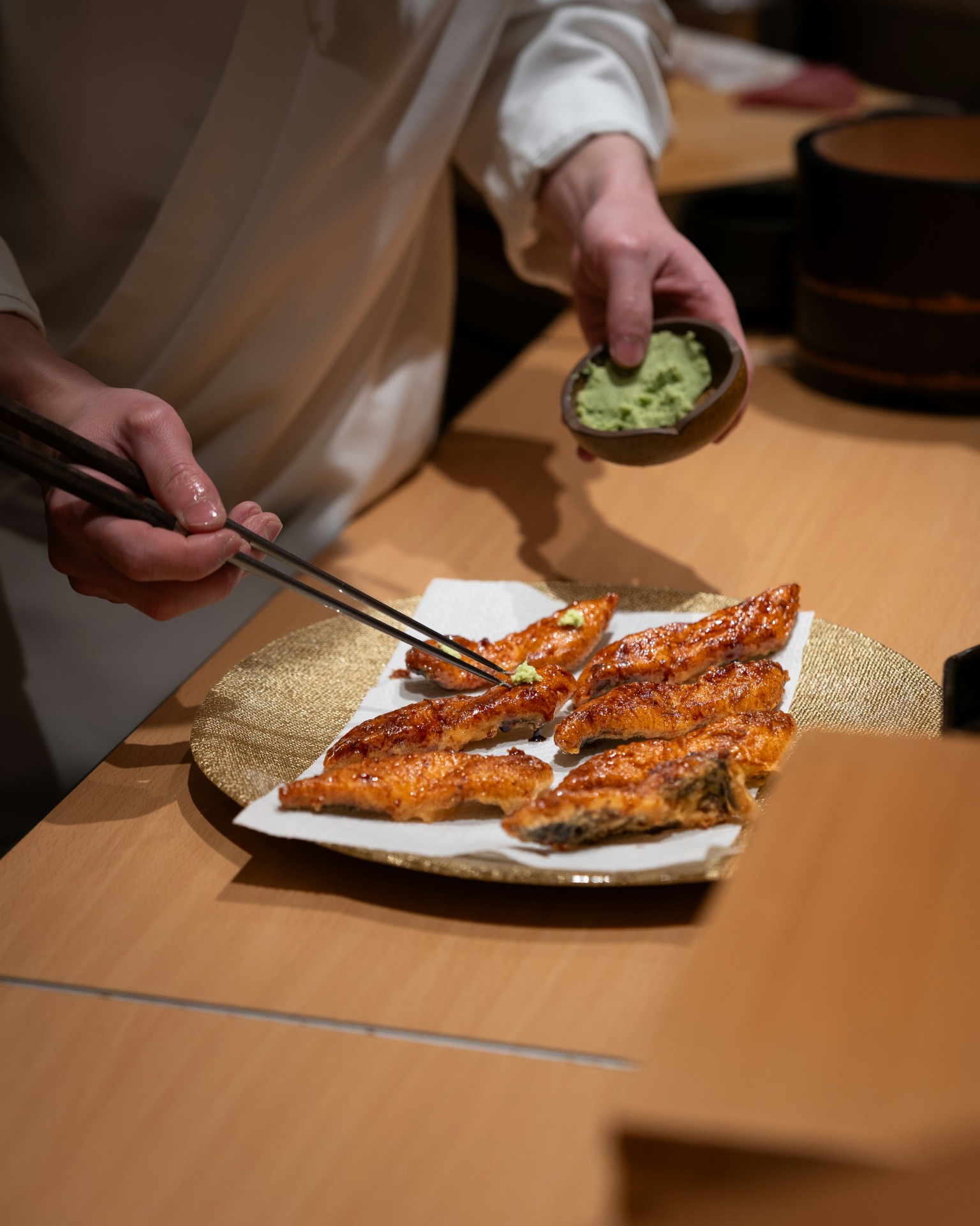 Chef sirviendo unagi a la parrilla con wasabi