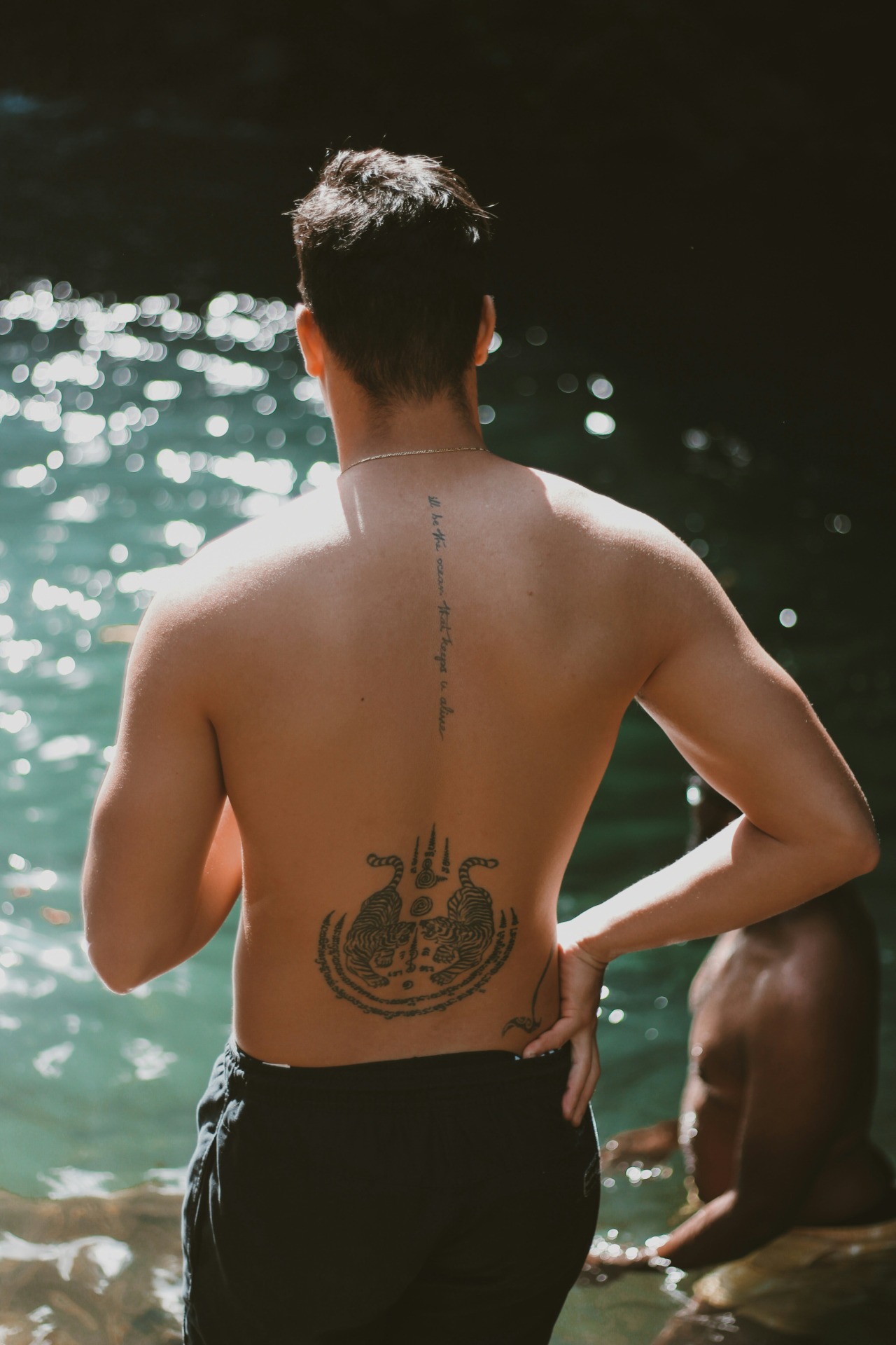 Viajero con tatuaje en la espalda baja en un onsen al aire libre