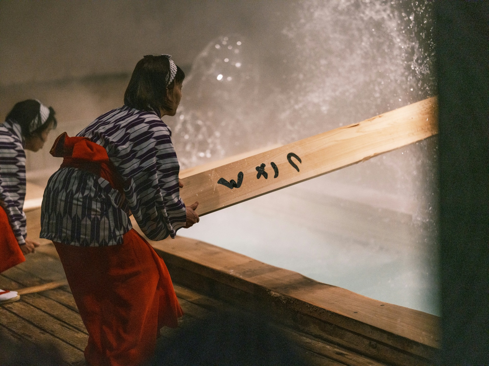 Yumomin en la ceremonia yumomi de Kusatsu removiendo el agua caliente