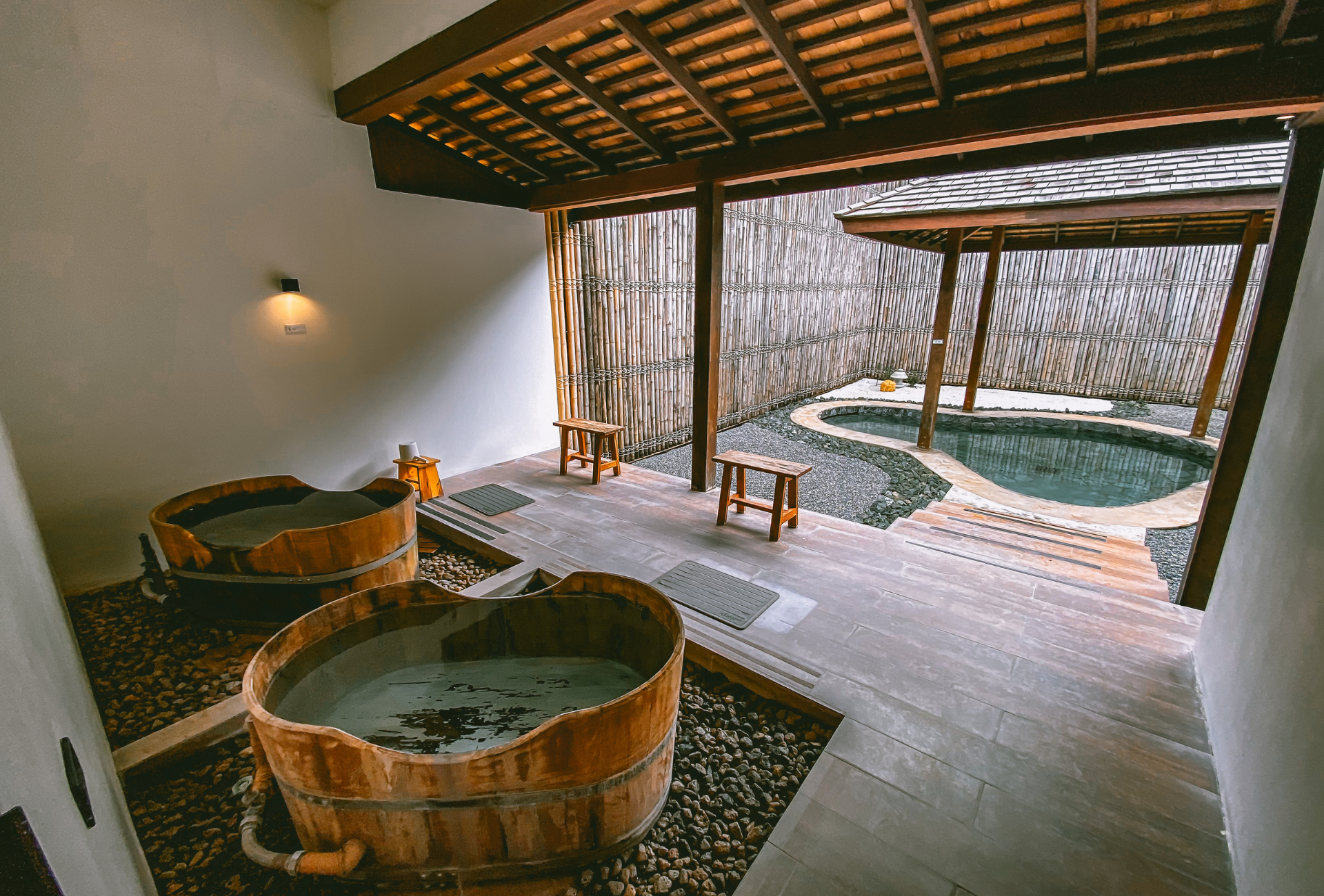 Onsen privado exterior con tinas de madera y jardín de grava japonés