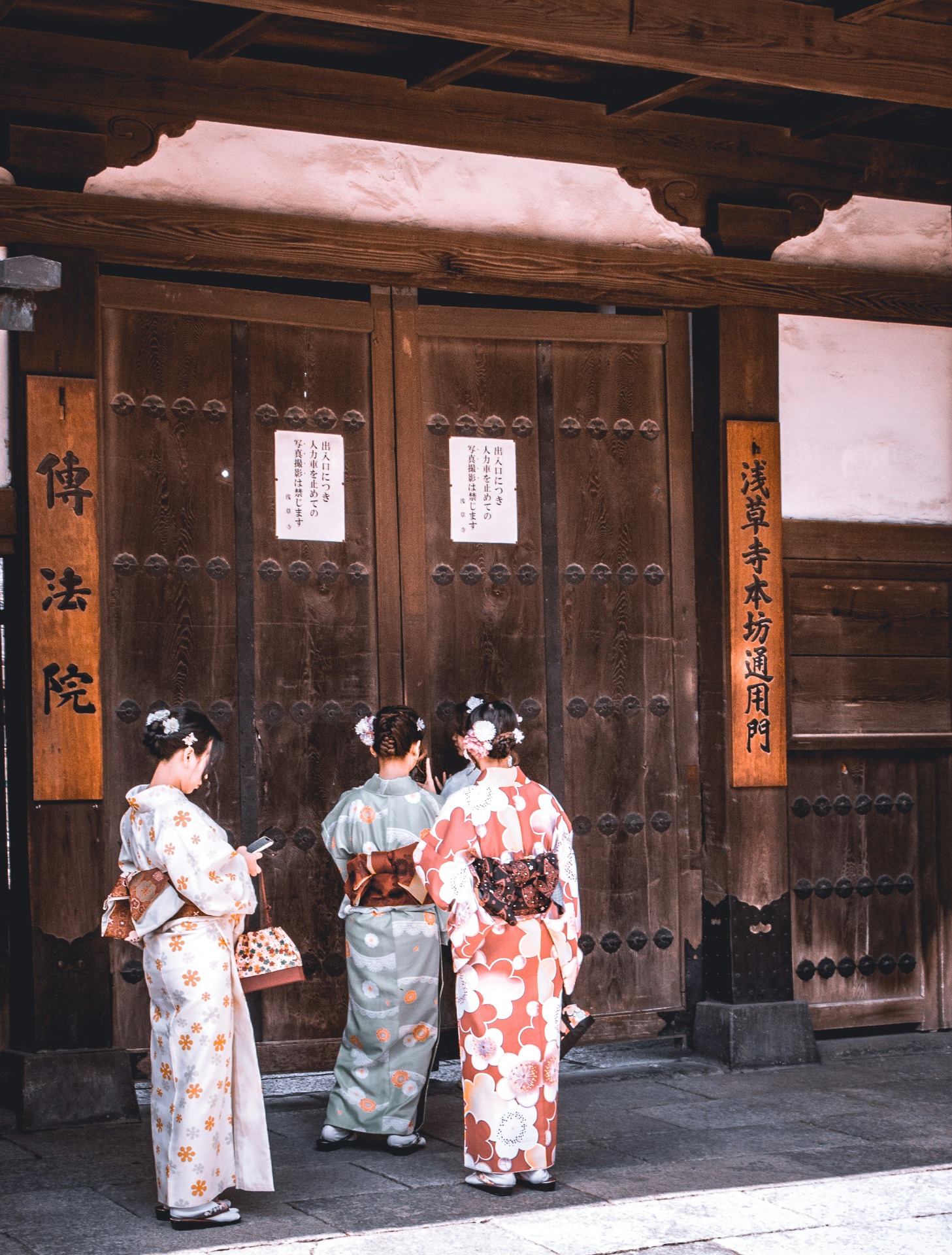 Un grupo de personas vestidas de kimono consultan el móvil