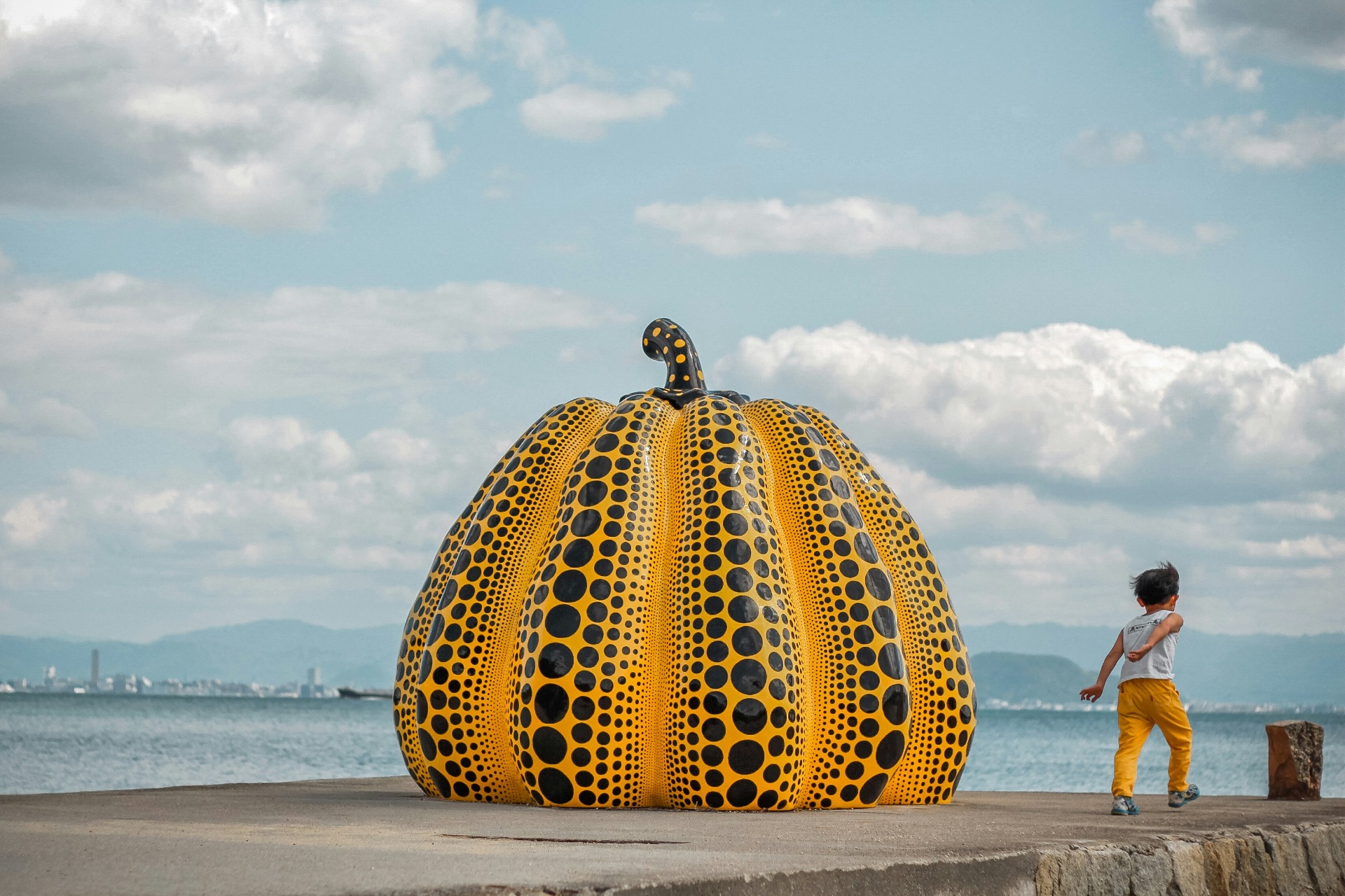 Un niño corre junto a la calabaza de Yayoi Kusama