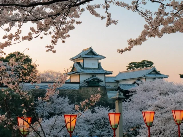 Castillo de Kanazawa entre cerezos en flor y farolillos al atardecer