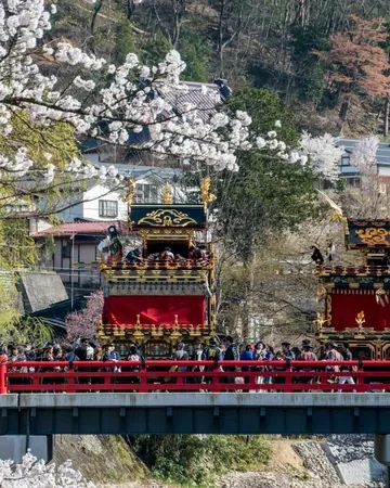 Carrozas del festival de Takayama sobre el puente rojo Nakabashi, entre cerezos en flor