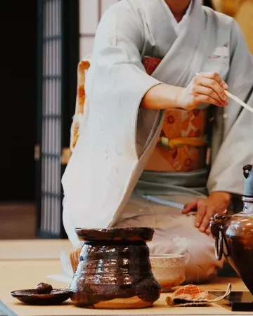 Maestra de té en kimono preparando el matcha sobre el tatami de una casa de té