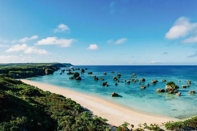 Playa de arena blanca y rocas en el agua turquesa de la costa de Okinawa