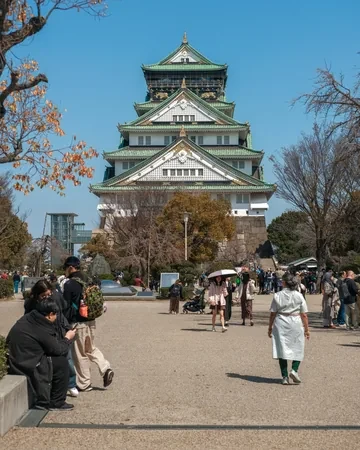 Castillo de Osaka con visitantes paseando por los jardines que lo rodean