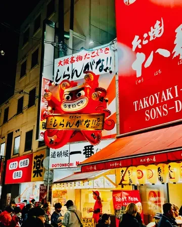 Puestos de takoyaki con sus letreros en Dotonbori, Osaka