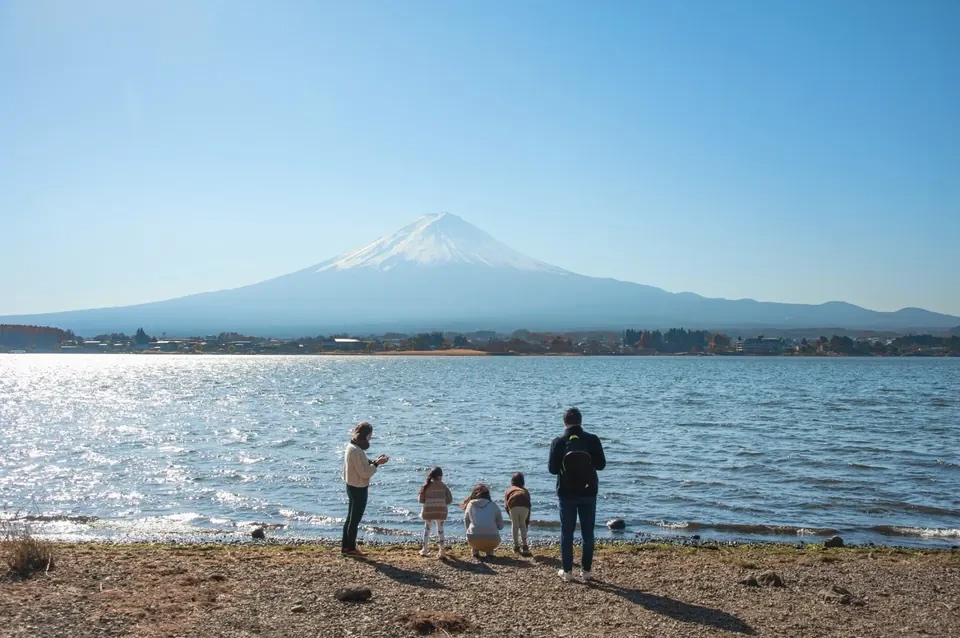Familia de viajeros de Japonal a orillas del lago Kawaguchi, frente al monte Fuji